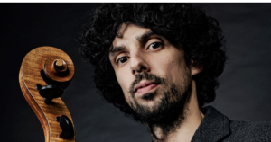 Daniel Claret souriant, tenant son violoncelle près de son visage