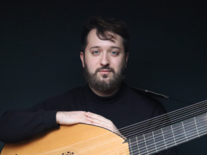 Kerry Bursey jouant d'un instrument à cordes, en tenue de concert sombre