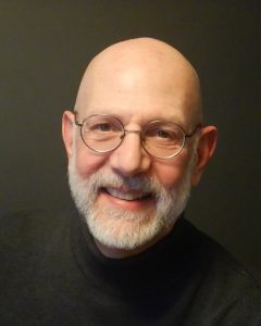 Portrait souriant de Robert Ingari, chef du Choeur de chambre du Québec, chandail noir